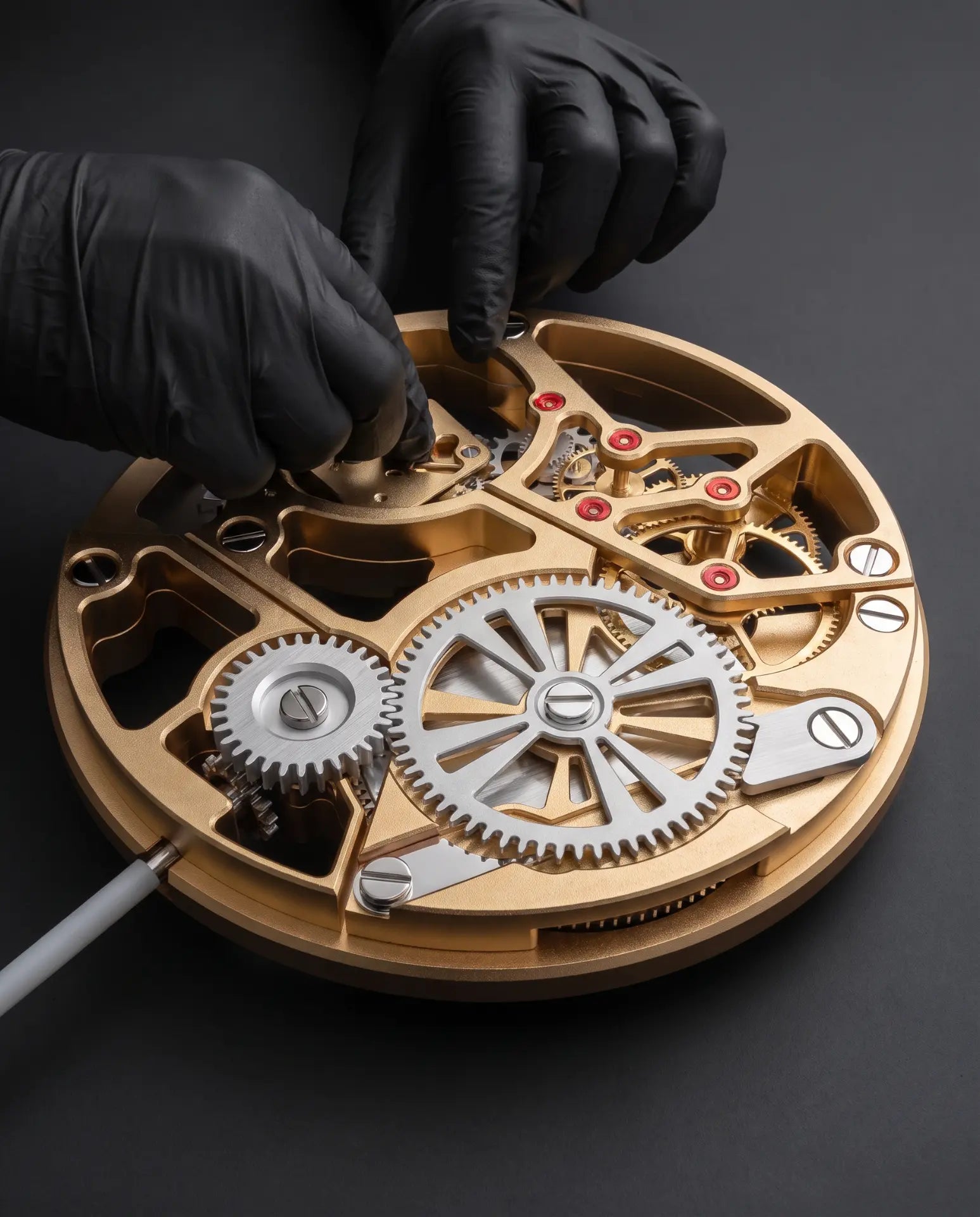 MECA TRADITION — Hand assembly of the champagne-anodized calibre in the atelier